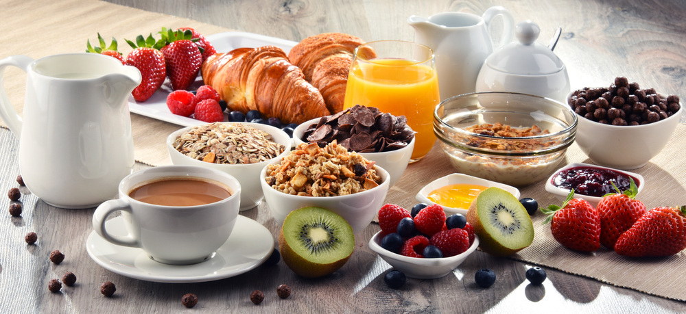 Вкусный завтрак на скорую руку: круассаны, кофе, сок, фрукты, ягоды, мюсли, овсяные хлопья