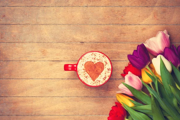 Кофе со взбитыми сливками около тюльпанов Стоковое Фото
