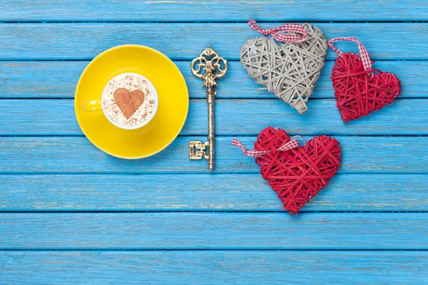 Чашка кофе со взбитыми сливками с символом в форме сердца, ключом и игрушками Стоковое Фото