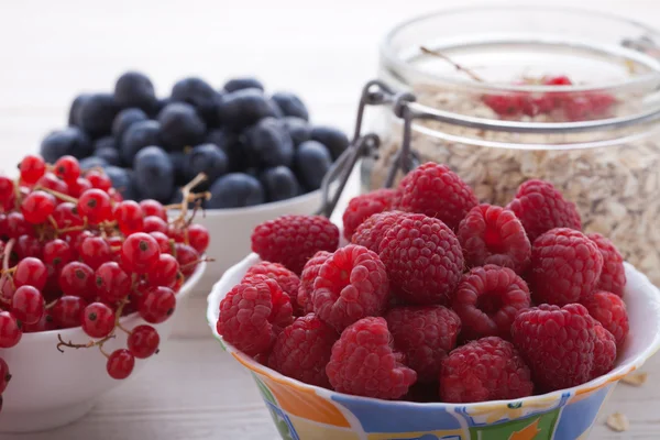 Breakfast - berries, fruit and muesli on white wooden — стоковое фото