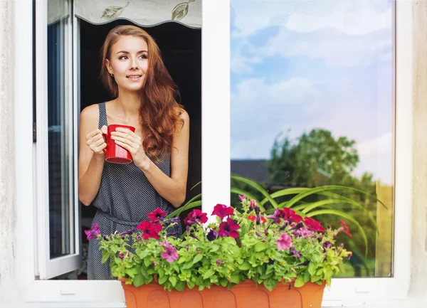 Женщина на балконе, наслаждаясь кофе утром Лицензионные Стоковые Изображения