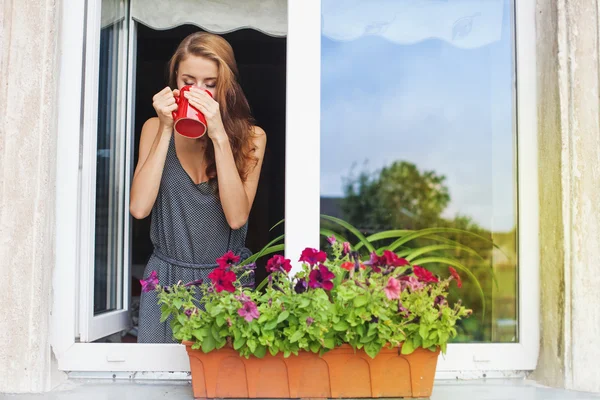 Женщина на балконе, наслаждаясь кофе утром Лицензионные Стоковые Фото