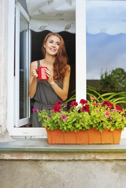 Женщина на балконе, наслаждаясь кофе утром Стоковая Картинка