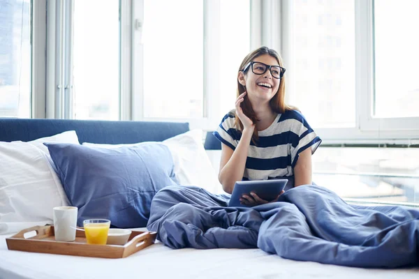 Завтрак в кровати для женщины в очках — стоковое фото