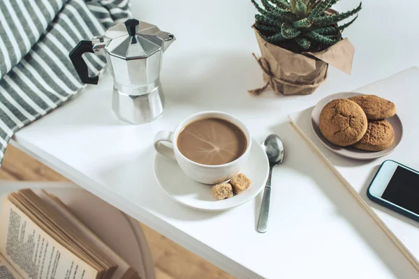 Кофе с печеньем и горшечное растение на столешнице — стоковое фото