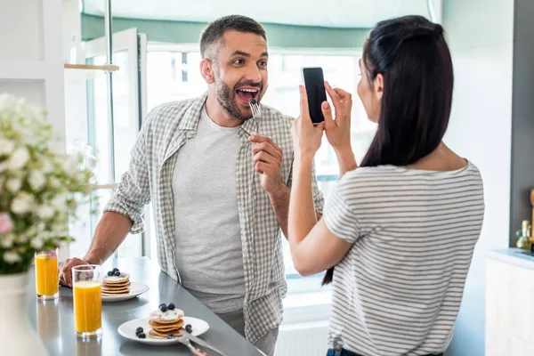 Woman Taking Picture Husband Playing Breakfast Counter Kitchen — стоковое фото